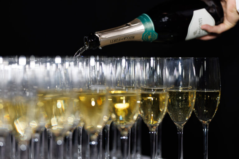 Champagne hældes i en række glas ved velkomsten
