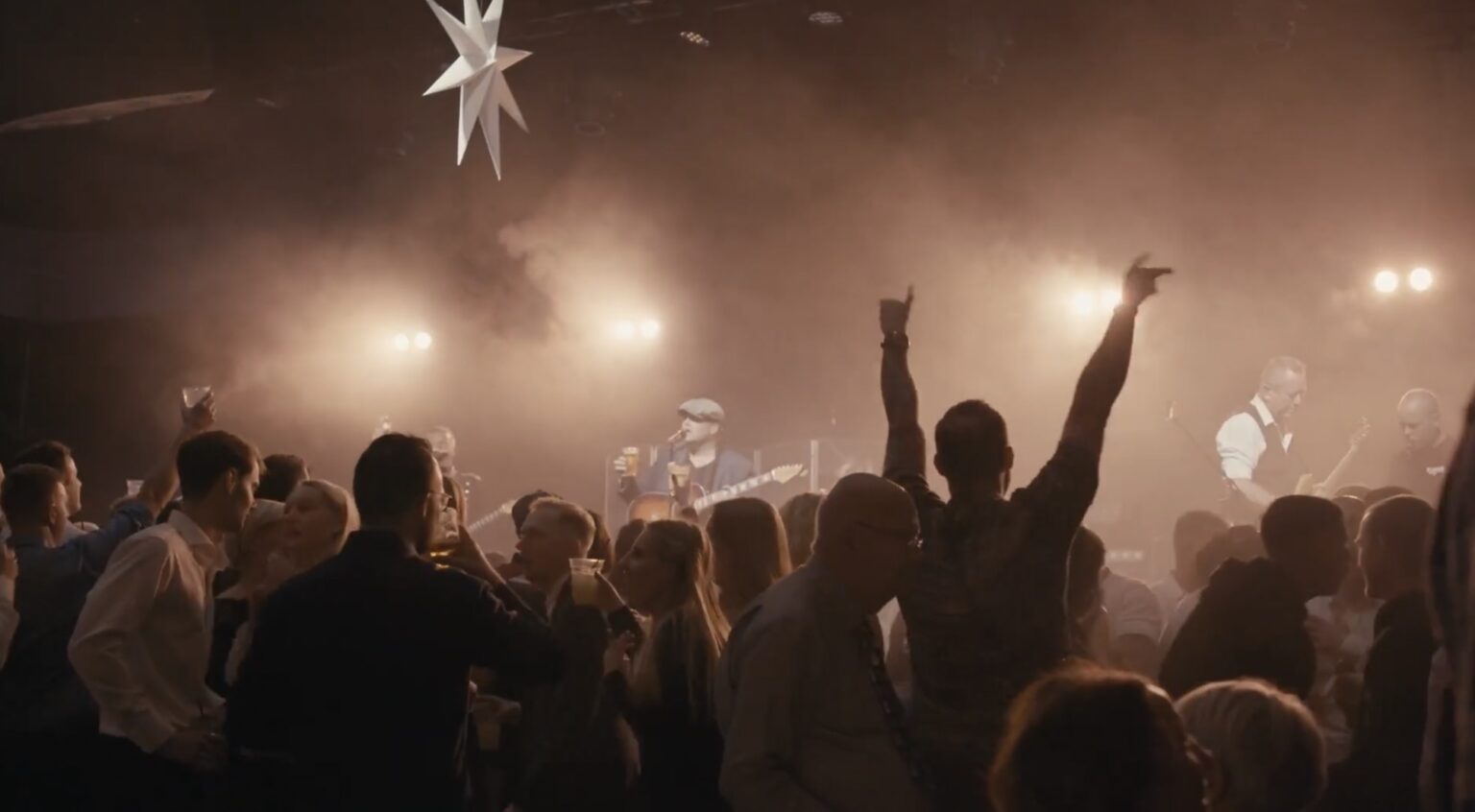 Gæster på dansegulvet foran scenen til fælles julefrokost i Terminal 13